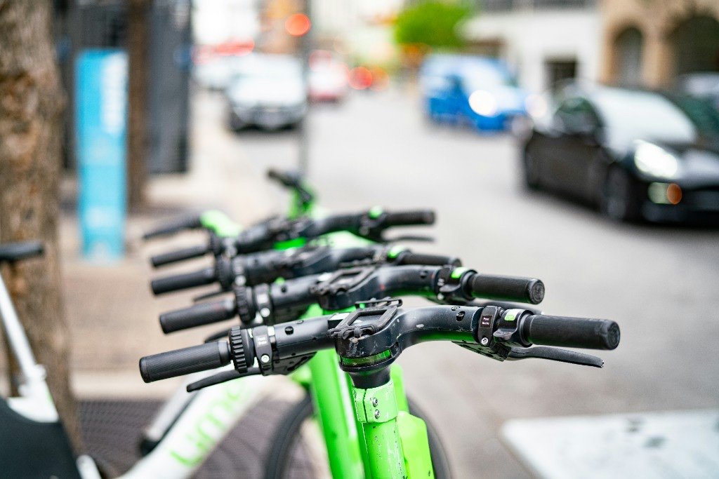 Shared e-scooters parked in a row on a city sidewalk